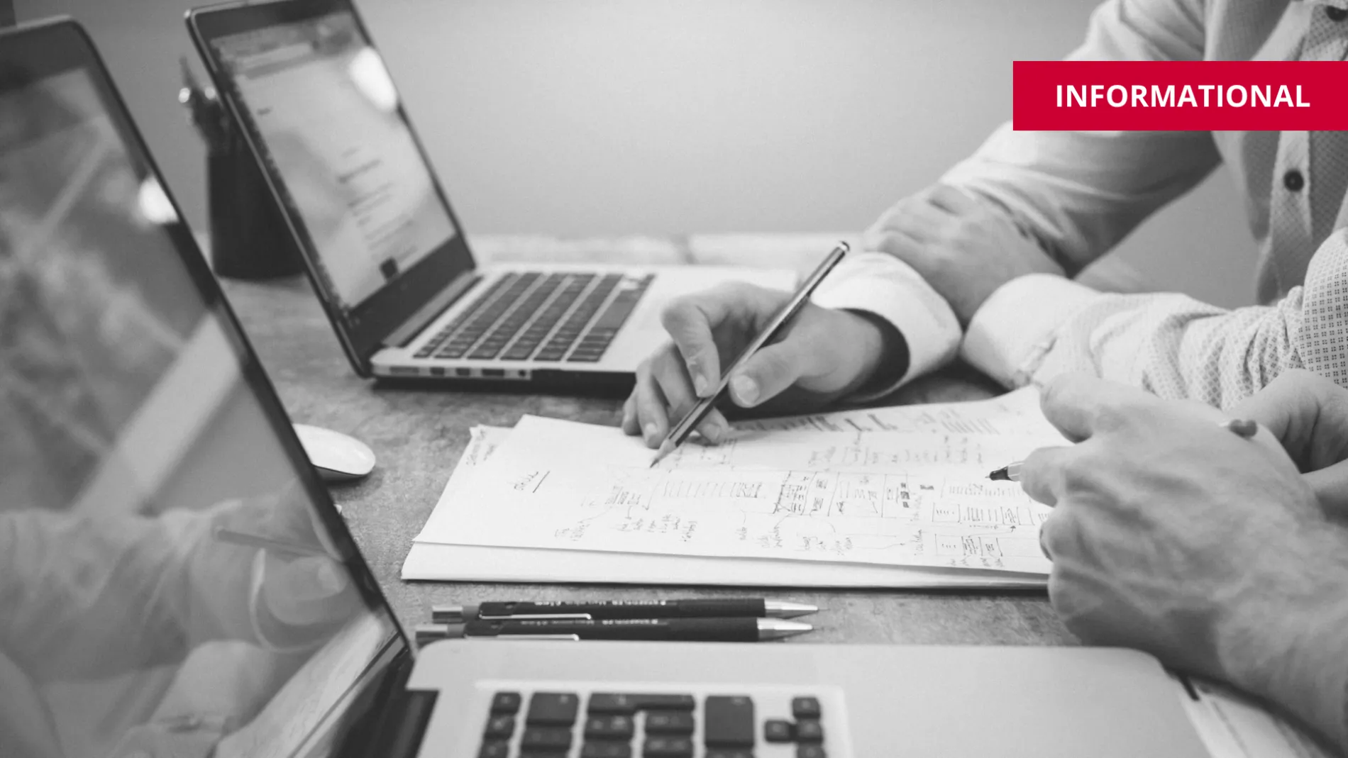 two people with laptops discussing the topic at hand