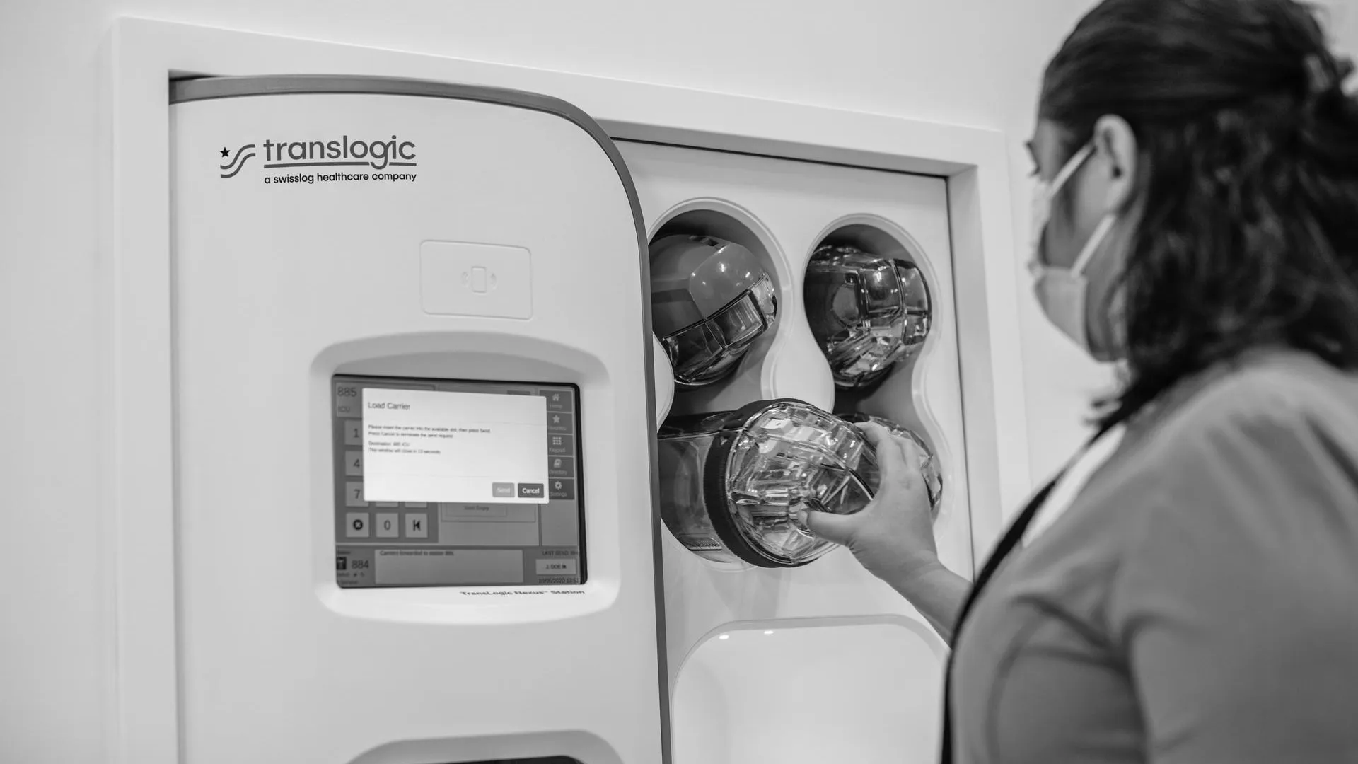 User taking carrier from TransLogic pneumatic tube system Nexus station