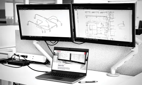 two computers showing bim 3d model and design plans